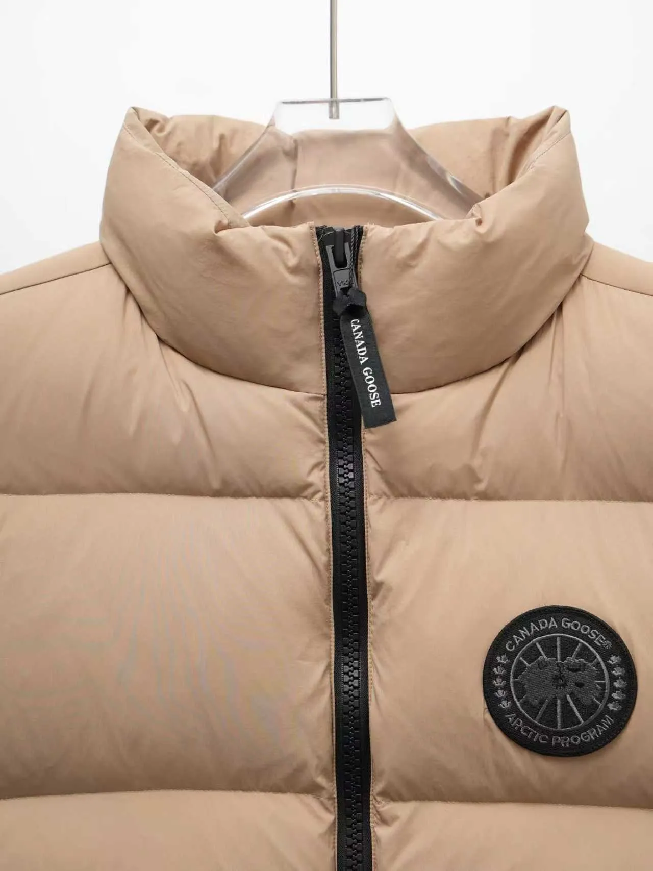 P580 Canada gooes Lawrence Down Vest (high version) With a durable shell and quilted body, the Lawrence Down Vest is a must-have for all seasons. The fabric has a durable soft touch. Longer hem at back for added protection. Reflective double-stripe grip tape at back. The Lawrence features an engineered down-filled collar to block strong winds, a two-way front zip and a longer rear hem. Color: black with red label, black with black label, desert color, ocean blue Size: XS -2XL